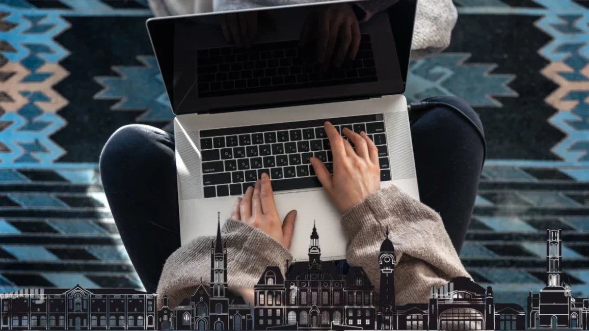 Image d'une femme travaillant sur son pc avec en filagramme la ville de limoges en bas de l'image