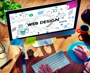 ordinateur avec une écriture web design en gros sur l'écran avec une personne qui tien souris et clavier